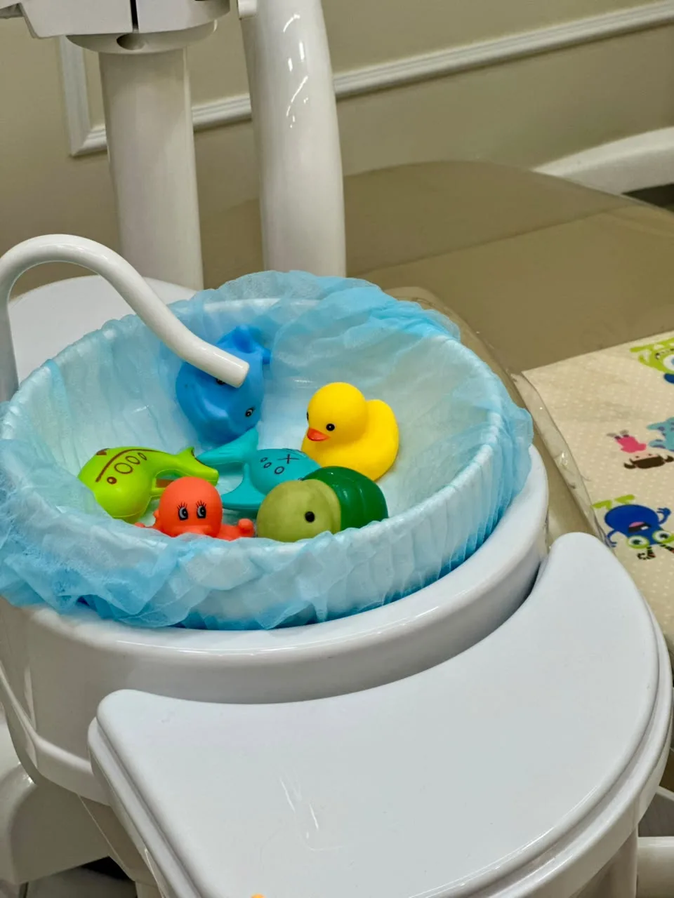 Brinquedinhos de banho em copo na cadeira odontológica