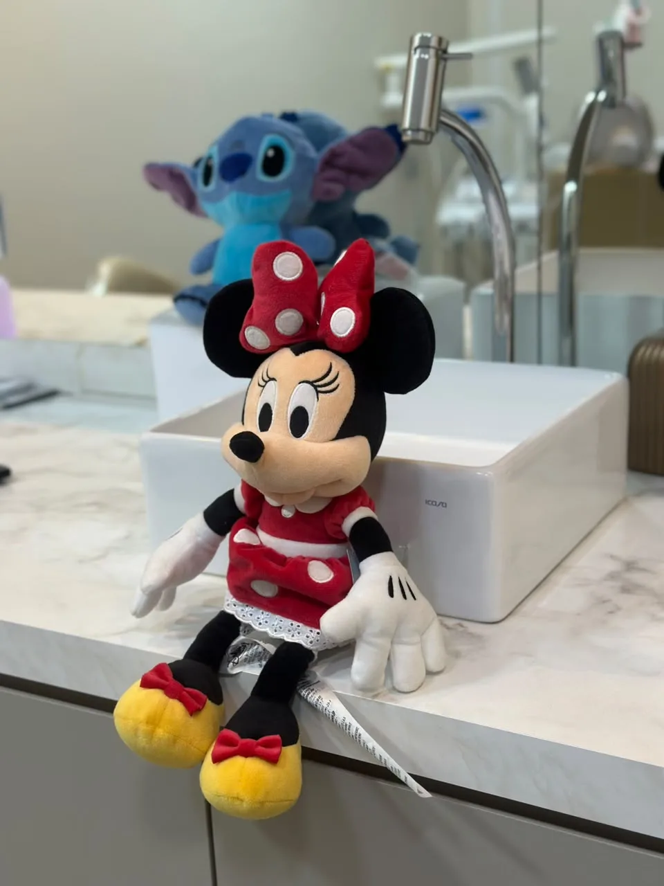 Pelúcias da Minnie e do Stitch na pia do consultório