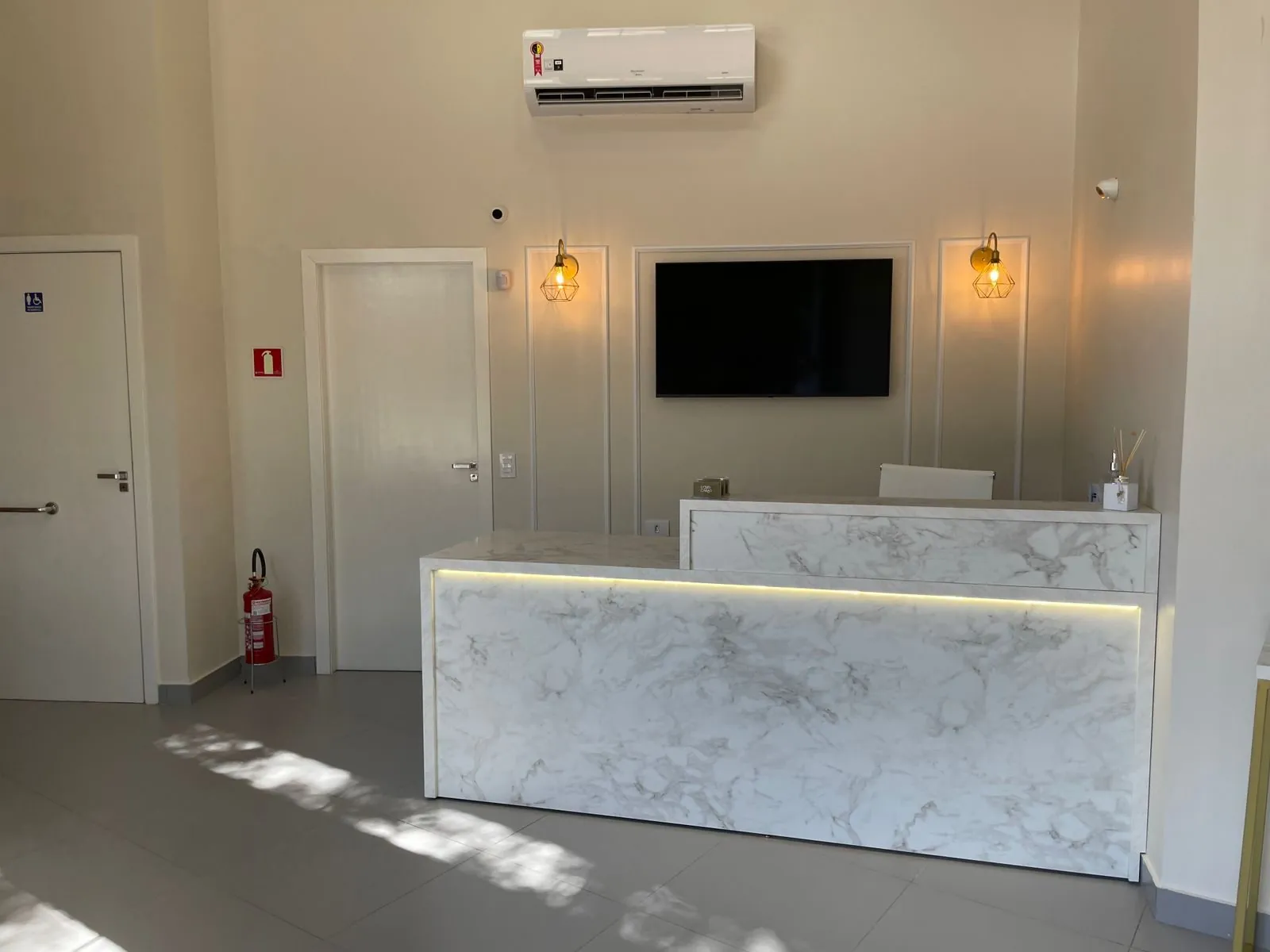 Recepção do consultório da Dra. Myleni Saúgo, com balcão em mármore